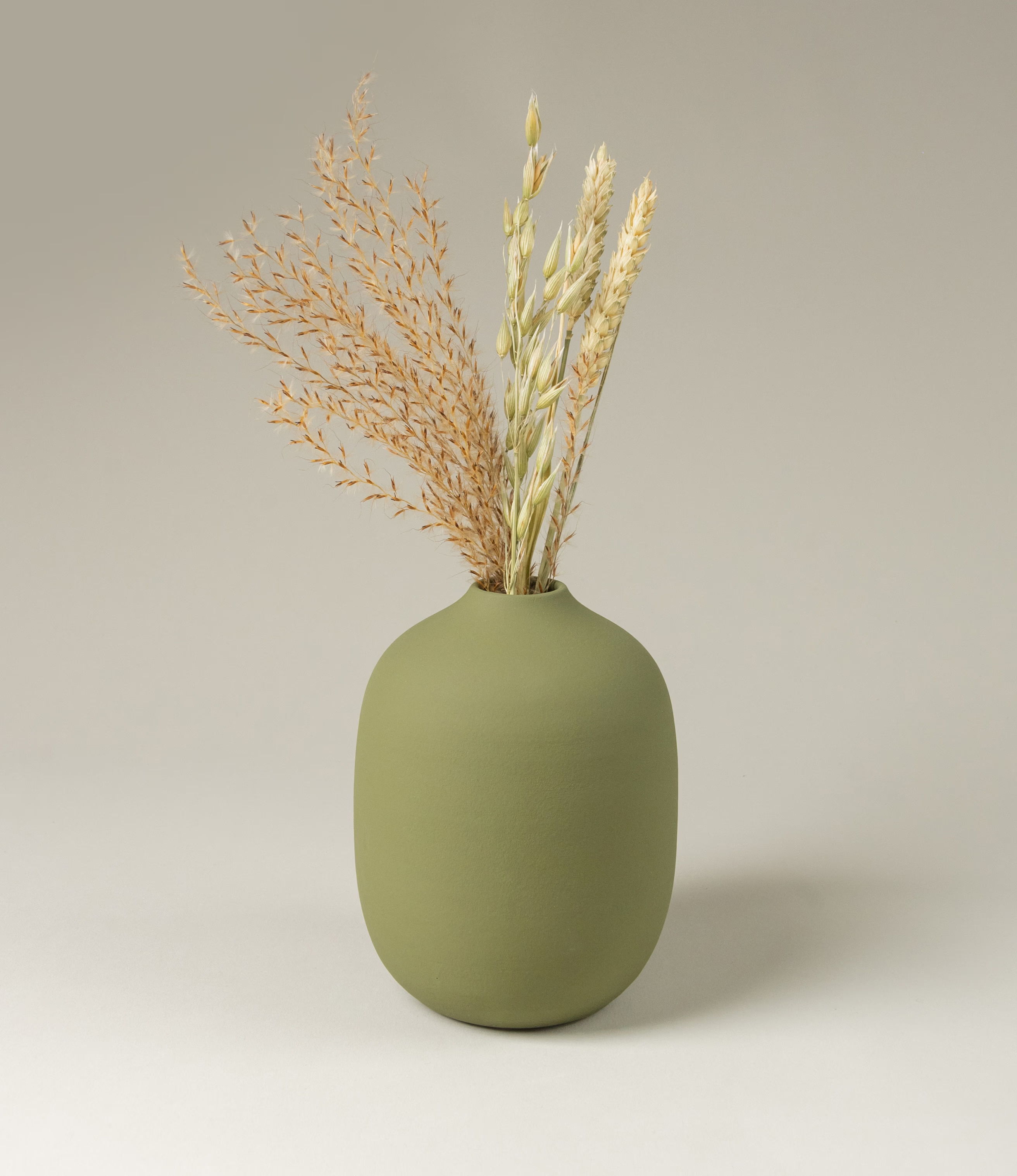 Ocactuu's green vase is a great fit to any flower. In this picture the item is matched with our Natural Dried Flowers. The natural olive green color blends in to any home perfectly. The shape is soft and smooth, with a small hole on top.